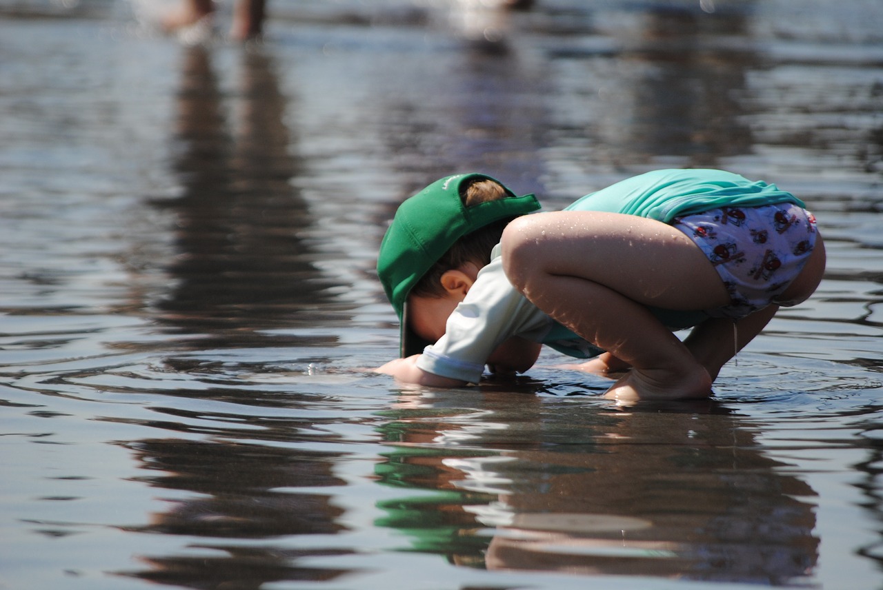 Child Playing In Water Toddler In Summer Child